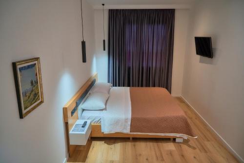 a bedroom with a bed and a window at Kalpazo Inn Tirana in Tirana