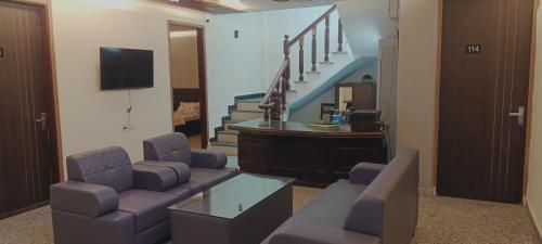 uma sala de estar com um sofá, uma mesa e escadas em Hotel Vinny em Jalandhar