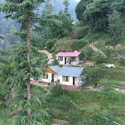 a house on the side of a hill at Jannat Cottages & Treehouse in Banjār