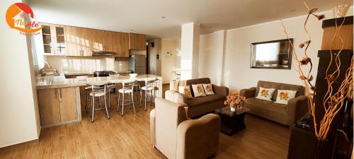 ein Wohnzimmer und eine Küche mit einem Sofa und einem Tisch in der Unterkunft NatAle Residencial - Departamento Segundo Piso con cochera in Tacna