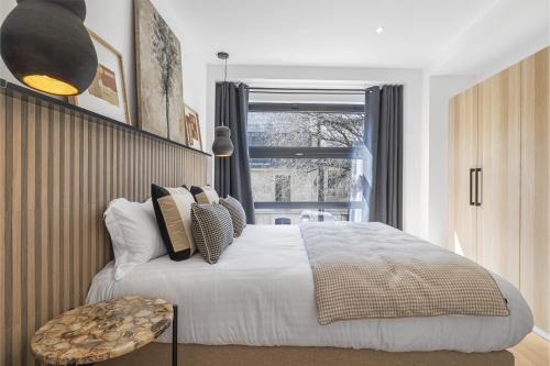 une chambre avec un grand lit et une fenêtre dans l'établissement Signature, à Paris