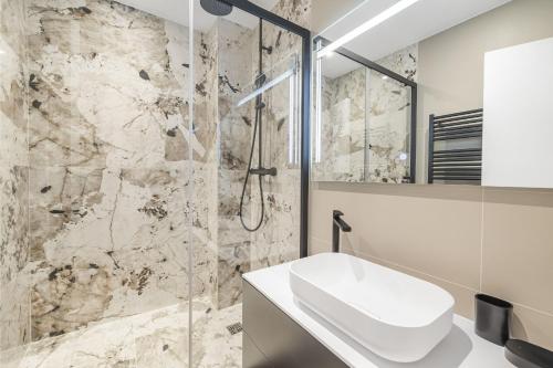 une salle de bain avec un lavabo et une douche dans l'établissement Signature, à Paris