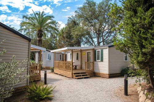 a row of mobile homes in a yard at Camping Santa Elena in Lloret de Mar