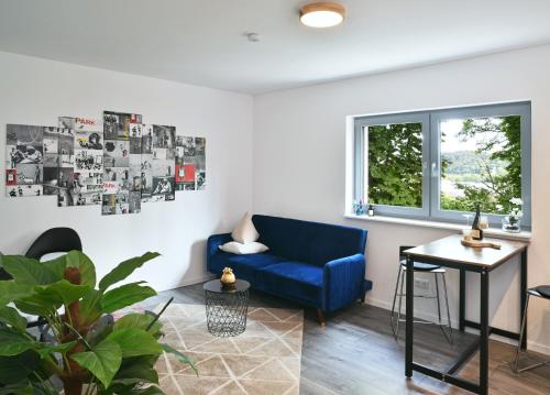 a living room with a blue couch and a table at Appartement im Grünen, zentral in Biberach in Biberach an der Riß