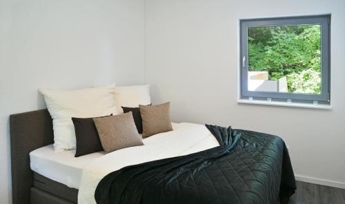 Schlafzimmer mit einem großen Bett und einem Fenster in der Unterkunft Appartement im Grünen, zentral in Biberach in Biberach an der Riß