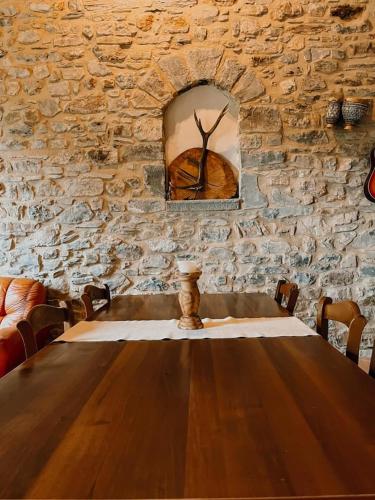 um quarto de pedra com uma mesa de madeira e uma parede de pedra em Agriturismo La Greciola em Gabbiana