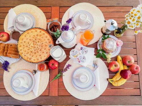 una mesa de madera con platos de desayuno y bebidas en Agriturismo La Greciola, en Gabbiana