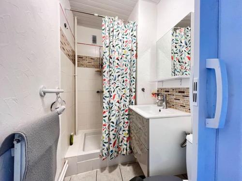 ein Badezimmer mit Duschvorhang und Waschbecken in der Unterkunft Joli studio vers les thermes, Anatole France -Royat in Royat