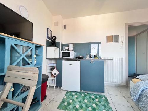 Elle comprend une petite cuisine équipée d'un réfrigérateur bleu et d'un four micro-ondes. dans l'établissement Joli studio vers les thermes, Anatole France -Royat, à Royat