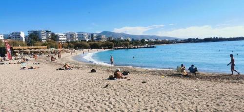 un grupo de personas en una playa cerca del agua en A room for girl girls lady couple share others with me and my bf en Atenas