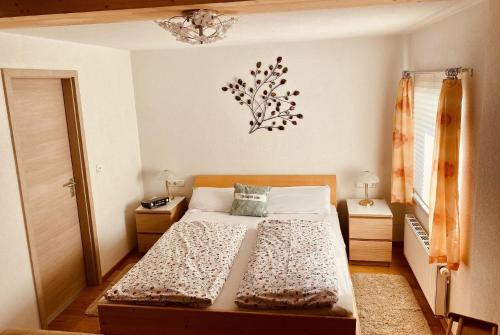 a small bedroom with a bed and a chandelier at Gemütliches Appartement in Pflach in Pflach