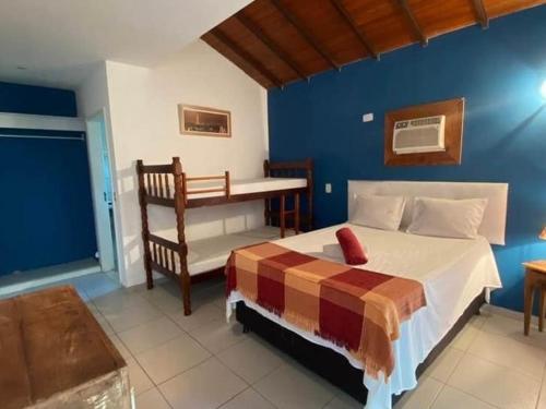 um quarto com uma cama e uma parede azul em Casa Marina VIP em Búzios