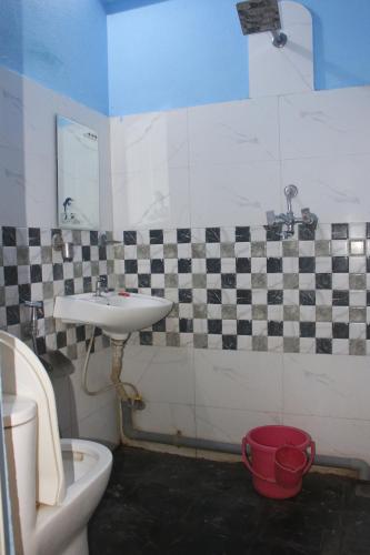 a bathroom with a sink and a toilet at Hotel Opera deluxe in Bharatpur