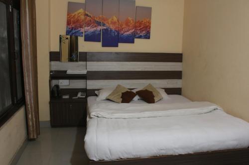 a bedroom with a bed with two pillows on it at Hotel Opera deluxe in Bharatpur