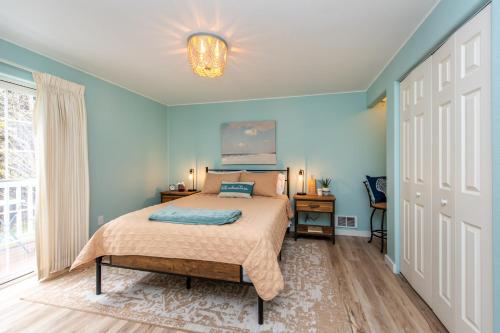 een slaapkamer met een bed met blauwe muren en een raam bij Sequim Escape with Gas Grill and Deck, Walk to Beach! in Sequim