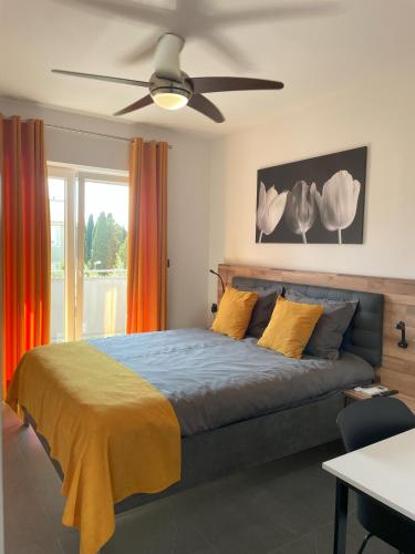 a bedroom with a bed with a ceiling fan at Valkane Beach Apartments in Pula