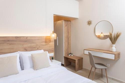 a bedroom with a white bed with a chair and a mirror at Dimitra Central Apartments Chanioti in Hanioti