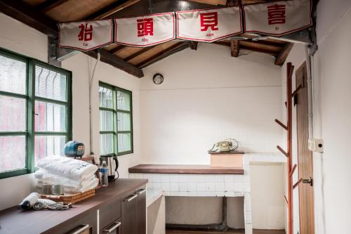 una cocina con letreros rojos y blancos colgando del techo en Xinghua Room, en Kaohsiung