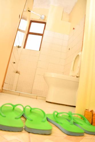 a bathroom with a pair of green scissors on the floor at Bed and breakfast studio apartments in Nairobi