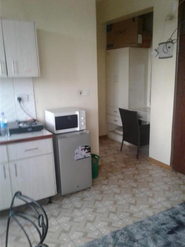 a kitchen with a microwave on top of a refrigerator at Bed and breakfast studio apartments in Nairobi