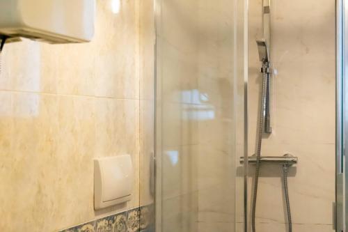 y baño con ducha y puerta de cristal. en Appartamento Spazioso a 30min da Cortina, en Domegge di Cadore