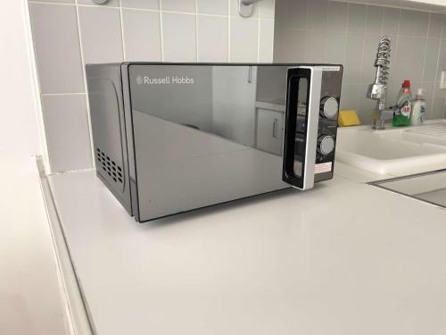 a microwave oven sitting on top of a kitchen counter at Bright and Beautiful 2BDR Central London Flat in London