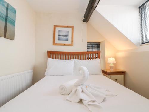 ein Schlafzimmer mit einem Bett mit weißen Handtüchern darauf in der Unterkunft Grimes Cottage in Staithes