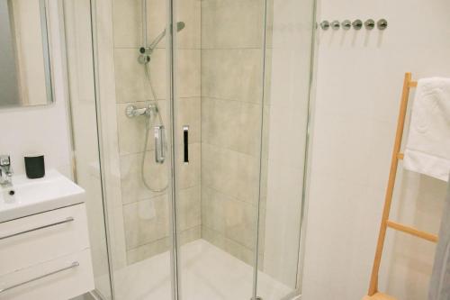 La salle de bains est pourvue d'une douche avec une porte en verre. dans l'établissement Apartament Nero, à Toruń