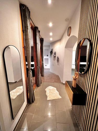 a hallway with two mirrors and a rug on the floor at Modern City Suites in Oberhausen