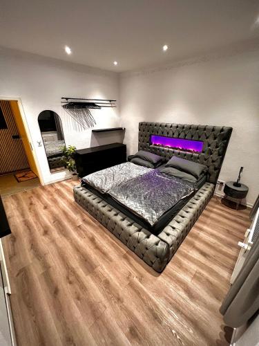 a bedroom with a bed with a purple light on it at Modern City Suites in Oberhausen