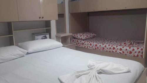 a bedroom with two beds with white sheets at Blue Haven in Shëngjin