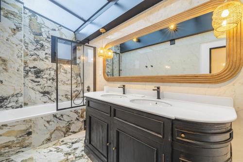 une salle de bain avec un lavabo et un miroir dans l'établissement Scarlett, à Paris