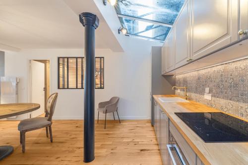 une cuisine avec une cuisinière et une table avec des chaises dans l'établissement Scarlett, à Paris