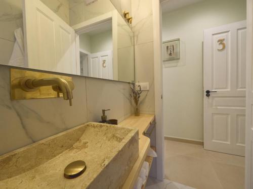 baño con lavabo y espejo grande en Hostal Casa Maria, en Batán del Puerto