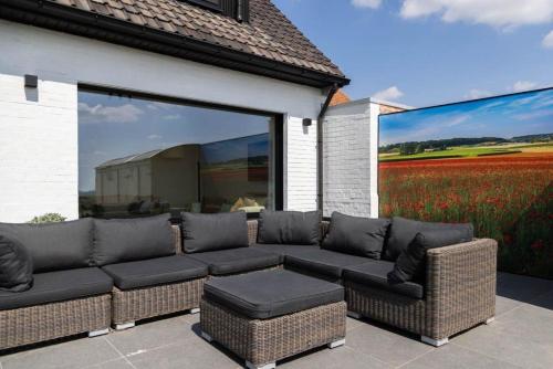 a patio with a couch and a large mural at Schönes Ferienhaus in Zonnebeke mit Privatem Pool in Zonnebeke