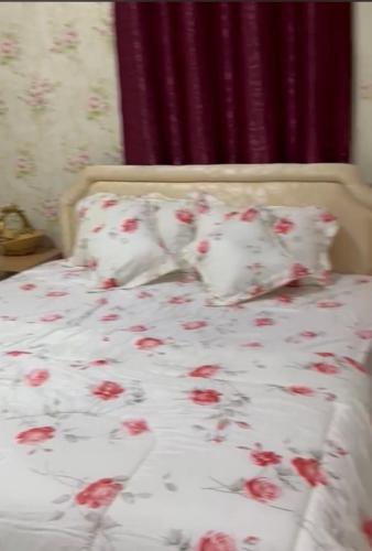 Una cama con flores rojas. en استراحة زمردة, en Khasab