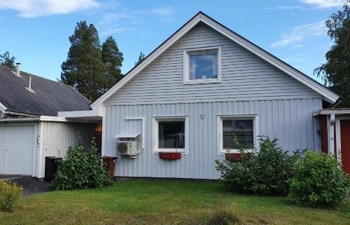 ein weißes Haus mit einem Fenster und einem Hof in der Unterkunft Ferienhaus in Vidsel mit Terrasse und Garten in Vidsel