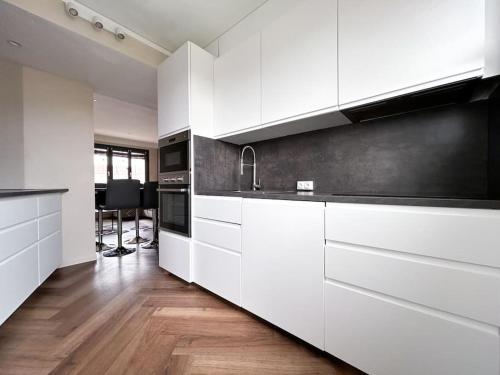 - une cuisine blanche avec des placards blancs et une table dans l'établissement Le Jardin des Plantes, à Nantes