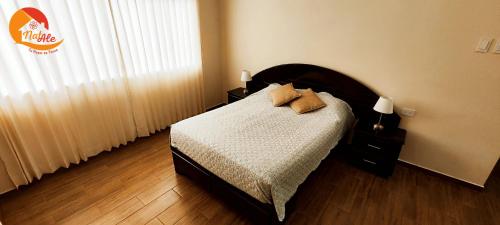 1 dormitorio con 1 cama con 2 almohadas en NatAle Residencial - Departamento Primer Piso con cochera, en Tacna