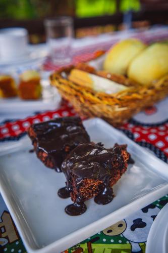 a plate of food with brownies and apples on a table at Pousada Equilíbrio dos Canyons in Praia Grande