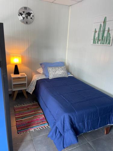 1 dormitorio con cama azul y mesita de noche en Clemst, en Curicó