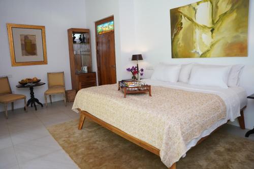 a bedroom with a bed and a table with flowers on it at VILLA BLUE LOTOUS in Gampaha