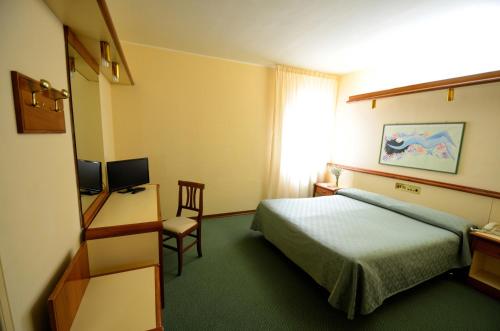 a hotel room with a bed and a desk and a chair at Grand Hotel delle Rocche in Rocca di Mezzo