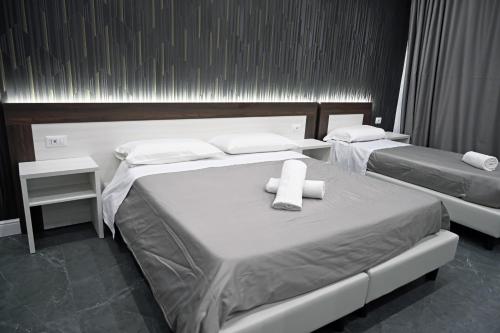 two beds in a hotel room with towels on them at Hotel Blanc in Casoria