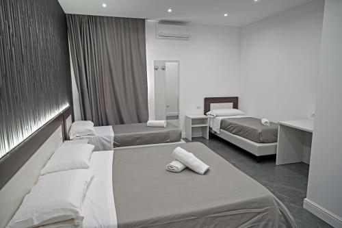 a hotel room with two beds with towels on them at Hotel Blanc in Casoria