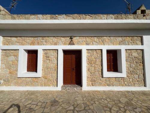 a stone building with two doors and two windows at Caserma Regina in Gourna