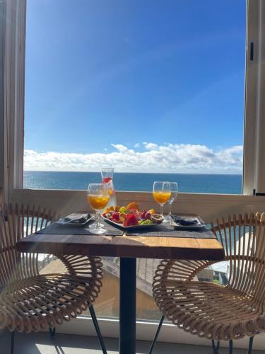 una mesa con dos copas de vino y un plato de fruta en Boutique Hotel Jardim Do Mar, en Jardim do Mar