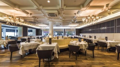 a dining room with white tables and chairs at Hotel Genziana in Ortisei
