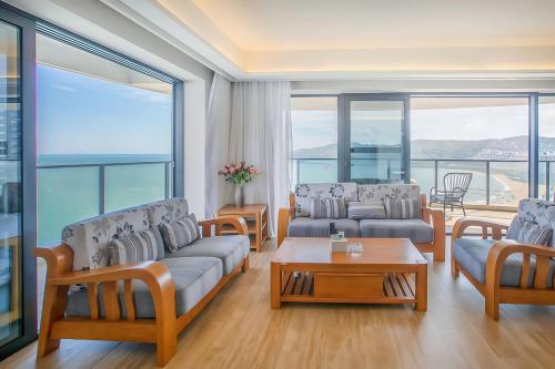 a living room with couches and a table at Xiaojing Bay Haige Hotel in Huidong
