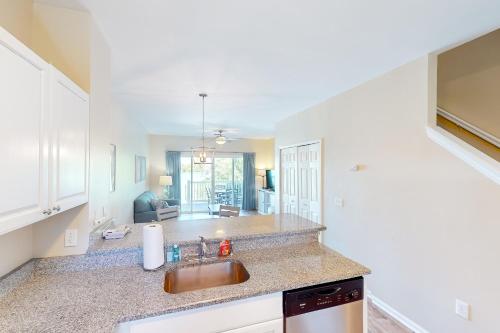 a kitchen with a sink and a living room at Coconut House in Duck Key